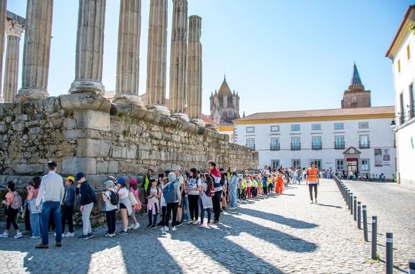 Crianças caminham junto ao Templo Romano de Évora numa atividade de descoberta do património — atividades para famílias em Évora