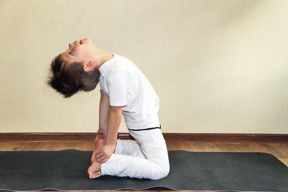 benefícios do yoga - foto stock - criança a fazer uma posição de yoga